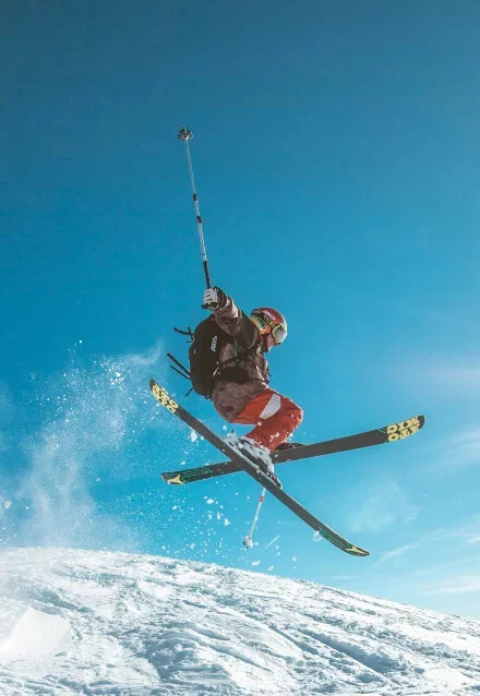 Homem esquiando em montanhas de gelo, mostrando esporte de inverno. Foto para web design de portfólio de atleta.